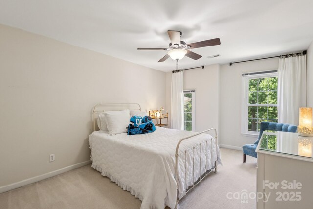 bedroom with light carpet, baseboards, and a ceiling fan