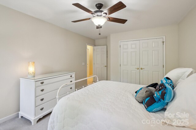 bedroom featuring a closet, light carpet, baseboards, and a ceiling fan