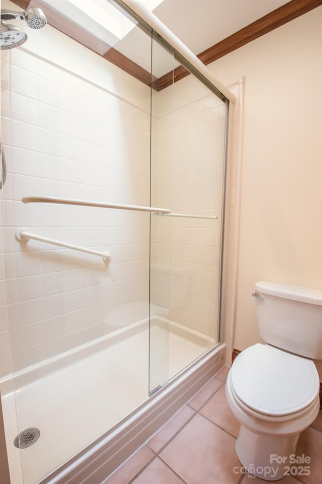 bathroom with toilet, a stall shower, and tile patterned floors