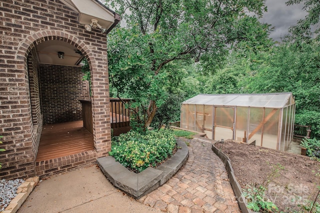 view of patio with an exterior structure, an outdoor structure, and a deck