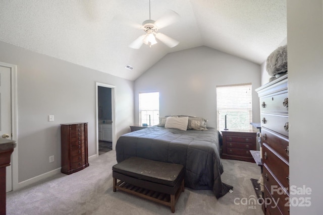 carpeted bedroom featuring connected bathroom, vaulted ceiling, visible vents, and ceiling fan