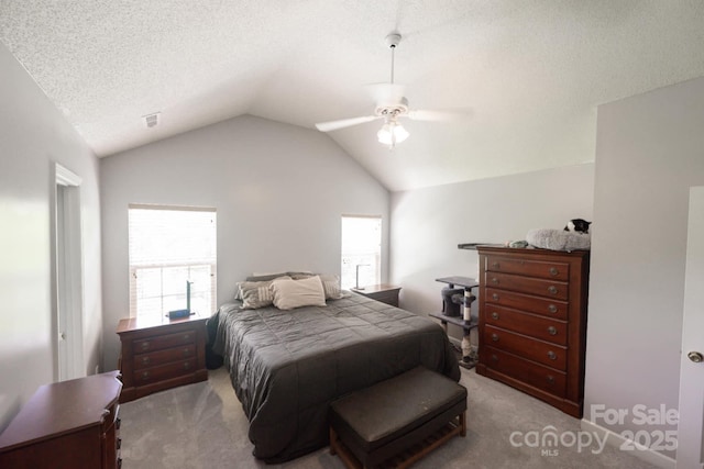 carpeted bedroom with a textured ceiling, vaulted ceiling, and a ceiling fan