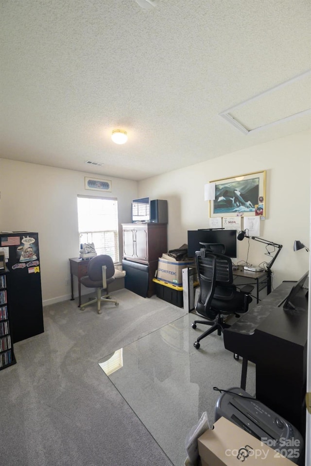 home office featuring carpet flooring, a textured ceiling, and visible vents