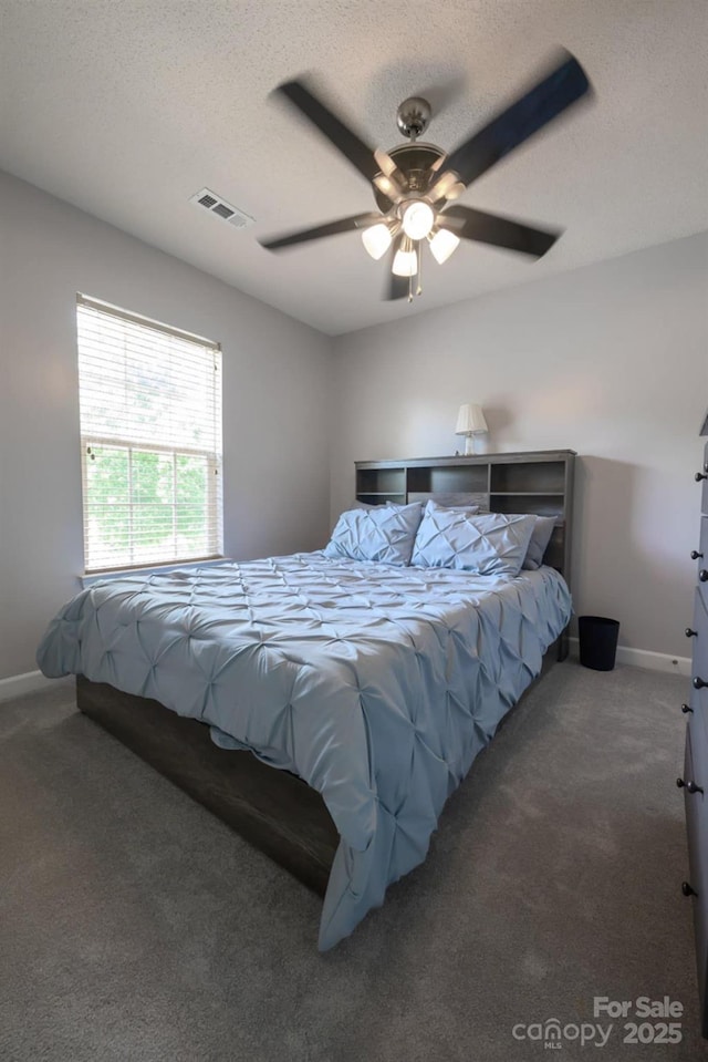 bedroom featuring baseboards, ceiling fan, visible vents, and carpet