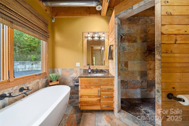 55 Maynards Way, Hendersonville, NC 28792 - bathroom featuring a walk in shower, a soaking tub, stone tile floors, vanity, and tile walls