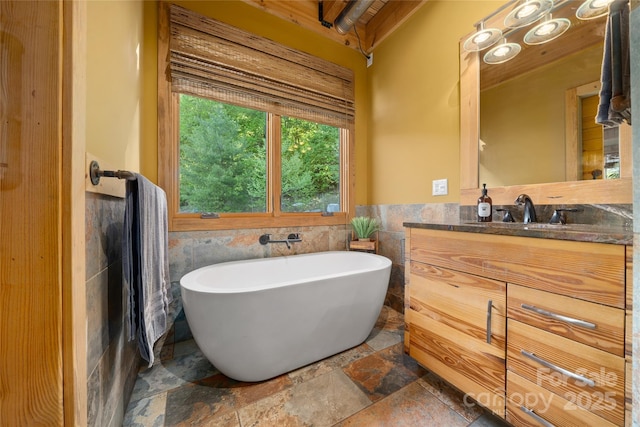 55 Maynards Way, Hendersonville, NC 28792 - bathroom with a soaking tub, vanity, stone finish floors, wainscoting, and tile walls