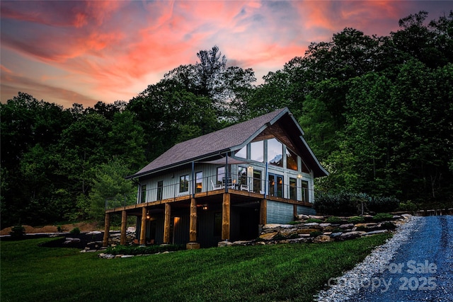 55 Maynards Way, Hendersonville, NC 28792 - back of property at dusk featuring a yard, a wooden deck, and a garage