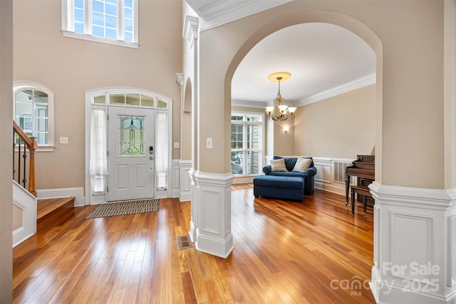 10452 Quiet Bay Ct, Charlotte, NC 28278 - foyer entrance featuring a chandelier, arched walkways, plenty of natural light, light wood finished floors, and ornamental molding