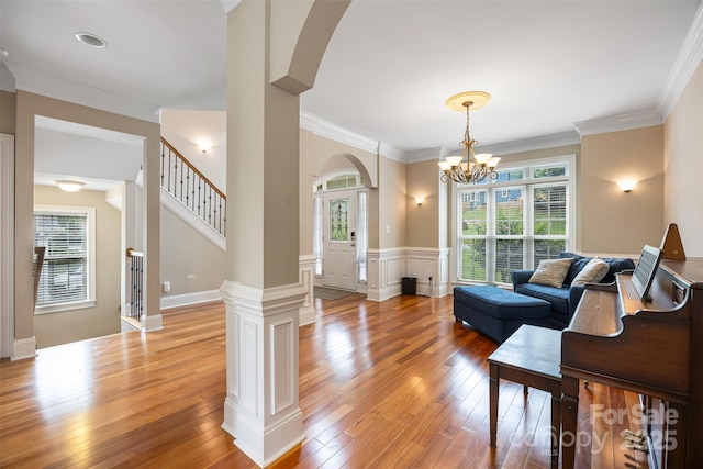 10452 Quiet Bay Ct, Charlotte, NC 28278 - living area featuring arched walkways, plenty of natural light, light wood-type flooring, crown molding, and wainscoting