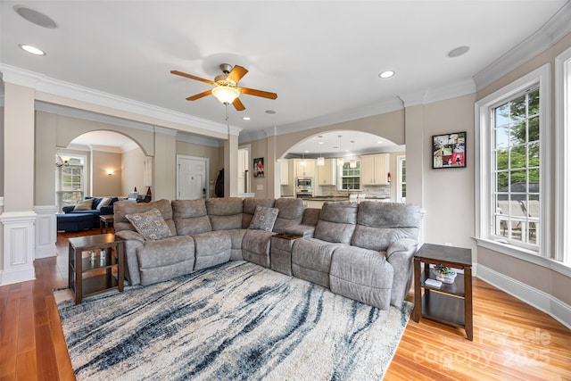 10452 Quiet Bay Ct, Charlotte, NC 28278 - living room featuring ceiling fan, arched walkways, light wood finished floors, healthy amount of natural light, and crown molding