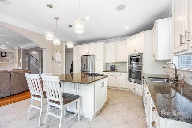 10452 Quiet Bay Ct, Charlotte, NC 28278 - kitchen with appliances with stainless steel finishes, a sink, ornamental molding, arched walkways, and decorative backsplash