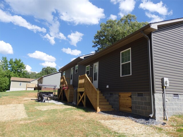 back of property featuring stairs and crawl space
