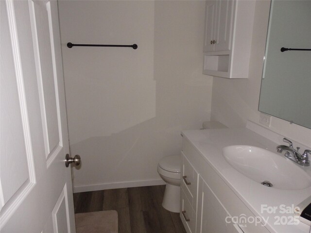 bathroom featuring wood finished floors, vanity, and toilet