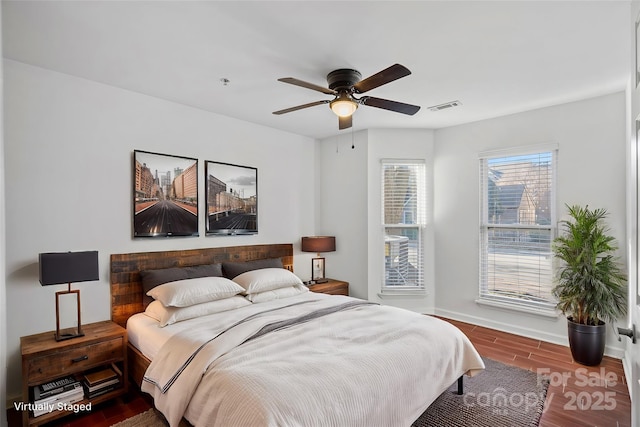 bedroom featuring wood finished floors, baseboards, and a ceiling fan