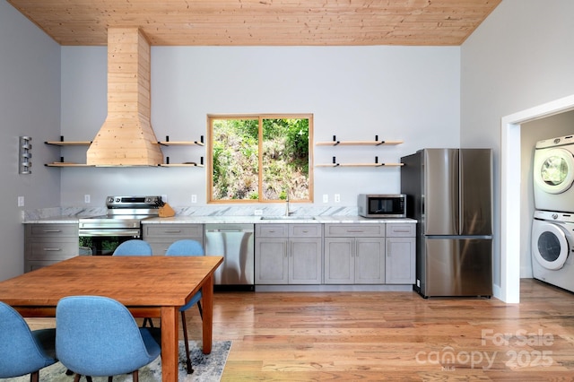 83 Mount Airy Rd, Marshall, NC 28753 - kitchen featuring open shelves, appliances with stainless steel finishes, stacked washer / drying machine, wood ceiling, and a sink
