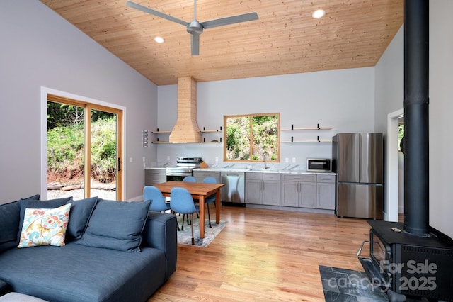 83 Mount Airy Rd, Marshall, NC 28753 - living area with a wood stove, wooden ceiling, light wood-style flooring, ceiling fan, and high vaulted ceiling
