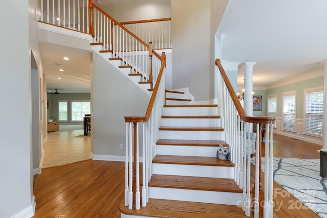stairs featuring ornamental molding, ceiling fan, and wood finished floors