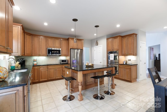 kitchen featuring decorative backsplash, stainless steel appliances, brown cabinets, and a kitchen bar