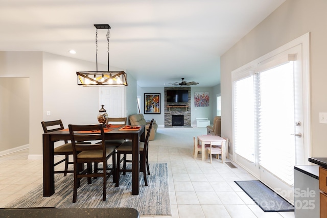 dining space with light tile patterned flooring, recessed lighting, ceiling fan, baseboards, and a stone fireplace