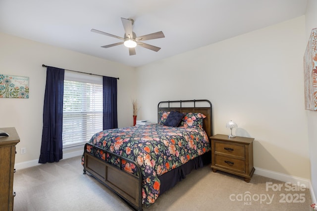 bedroom with light colored carpet, baseboards, and a ceiling fan