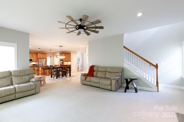 living area featuring a ceiling fan, recessed lighting, baseboards, stairway, and light colored carpet