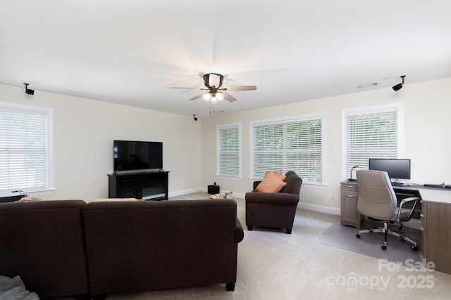 living room featuring a ceiling fan, baseboards, visible vents, and light colored carpet