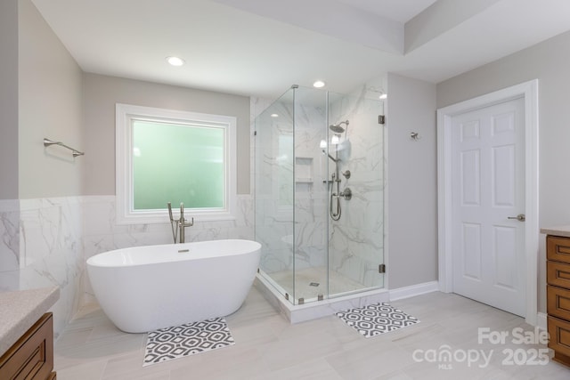 full bathroom with a soaking tub, a marble finish shower, vanity, and recessed lighting