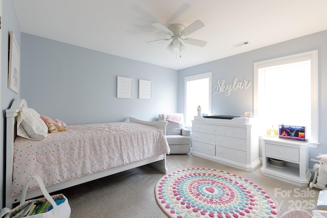 bedroom with multiple windows, visible vents, ceiling fan, and carpet