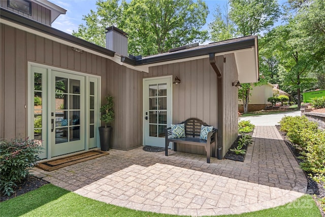 back of property with a chimney and a patio