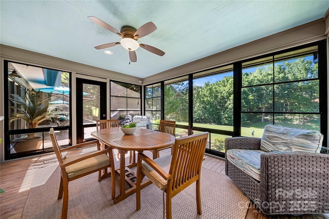 sunroom with ceiling fan and outdoor dining space