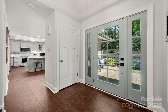 doorway to outside with vaulted ceiling and dark wood-style floors