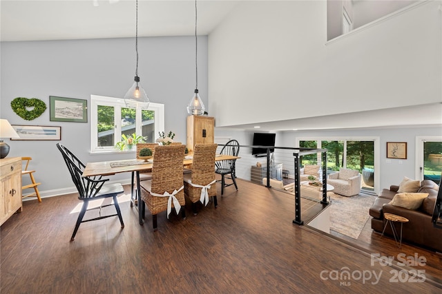 dining room featuring high vaulted ceiling, dark wood-style floors, and baseboards