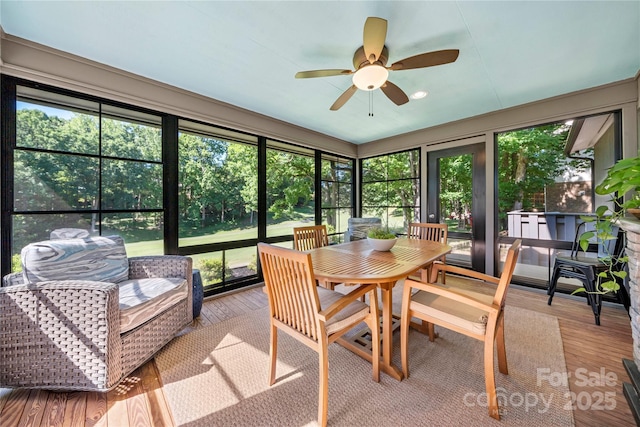 sunroom with ceiling fan, outdoor dining space, and healthy amount of natural light
