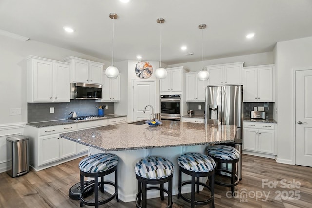 1360 Dali Blvd, Mount Holly, NC 28120 - kitchen featuring stainless steel appliances, a sink, a kitchen bar, white cabinetry, and recessed lighting