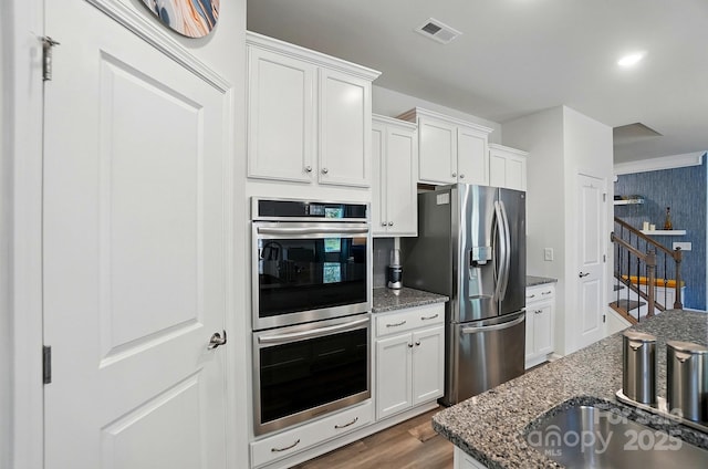 1360 Dali Blvd, Mount Holly, NC 28120 - kitchen with appliances with stainless steel finishes, dark stone counters, white cabinetry, wood finished floors, and a sink