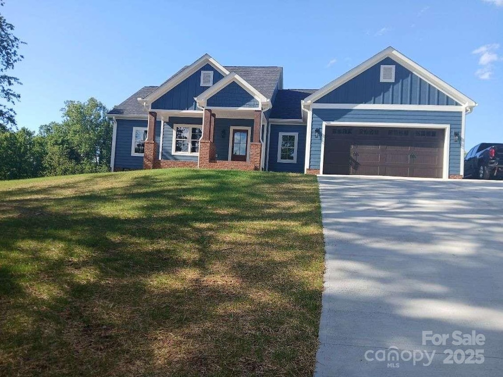 craftsman-style house with board and batten siding, concrete driveway, an attached garage, and a front yard