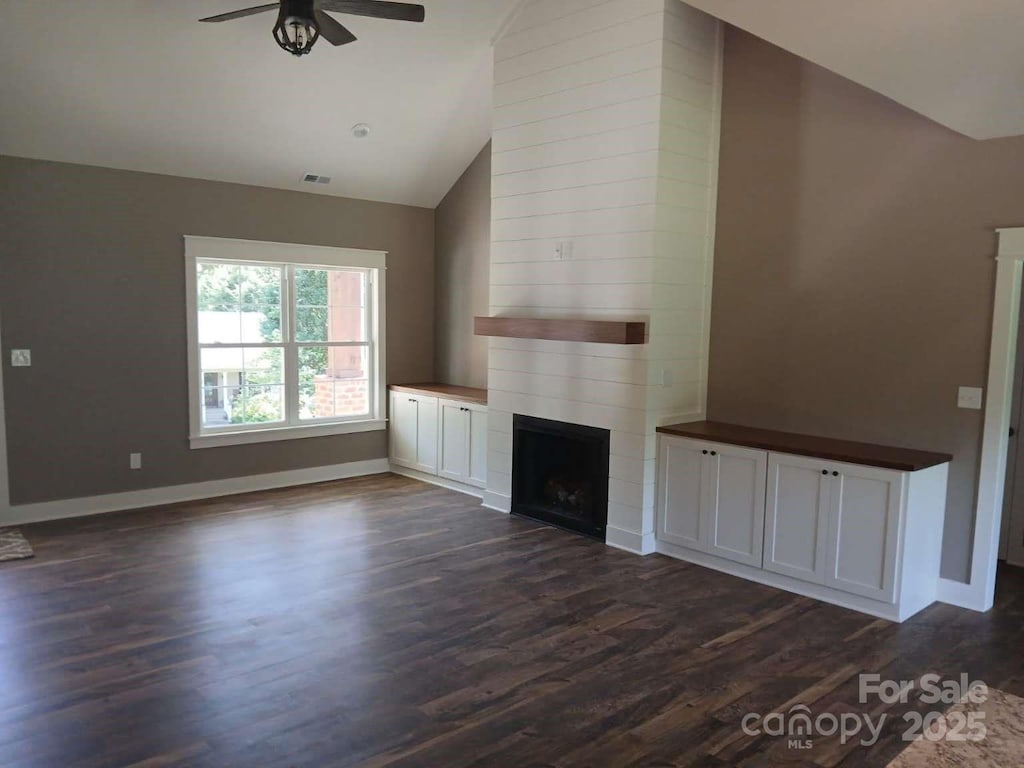 18 Morningside Dr, Granite Falls, NC 28630 - unfurnished living room featuring a ceiling fan, a large fireplace, dark wood-style flooring, high vaulted ceiling, and baseboards