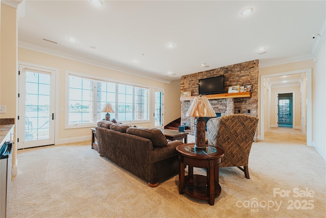 living room with light colored carpet, a stone fireplace, ornamental molding, baseboards, and recessed lighting