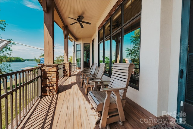 balcony featuring ceiling fan and a water view