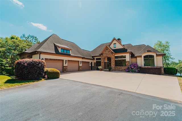 craftsman inspired home with stone siding, driveway, stucco siding, an attached garage, and a chimney