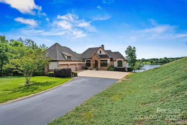 6205 Plantation Pointe Dr, Granite Falls, NC 28630 - french country home featuring stone siding, an attached garage, asphalt driveway, a front yard, and a water view
