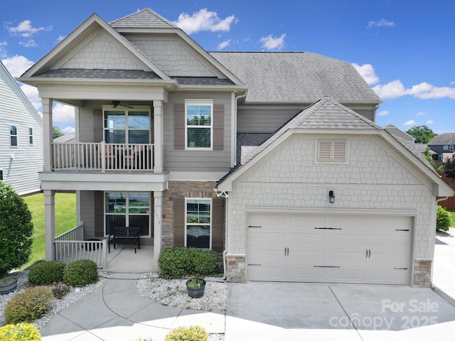 2015 Knocktree Dr, Indian Trail, NC 28079 - craftsman-style home featuring a balcony, an attached garage, concrete driveway, stone siding, and roof with shingles