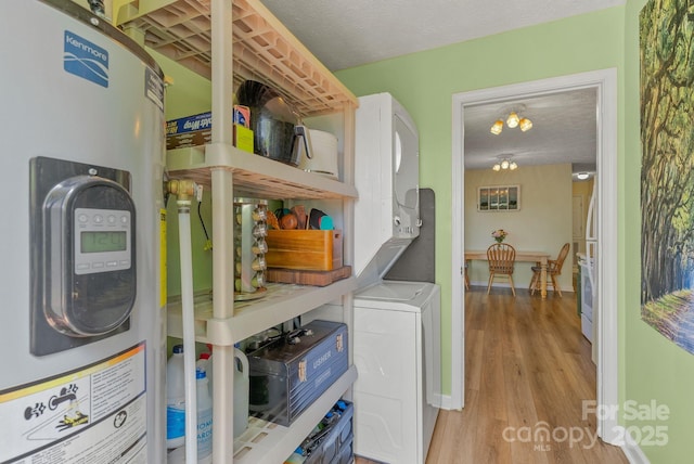 11 Louisville Pl, Asheville, NC 28806 - washroom featuring water heater, stacked washing machine and dryer, and wood finished floors