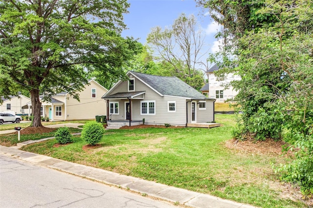 225 N Lee St, Mount Holly, NC 28120 - view of front of house featuring a front yard, covered porch, and a shingled roof