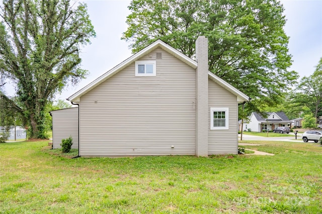 225 N Lee St, Mount Holly, NC 28120 - view of home's exterior featuring a chimney and a yard