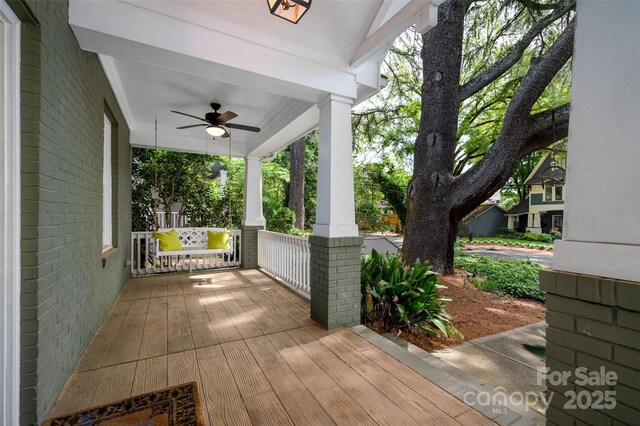 wooden deck with a porch and ceiling fan