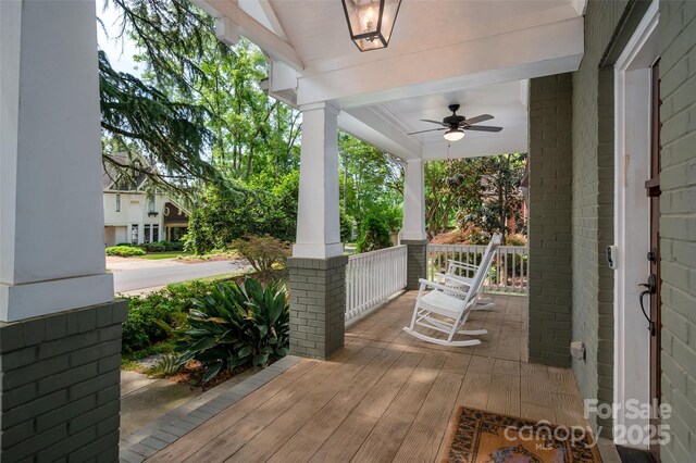 wooden deck featuring a porch and a ceiling fan