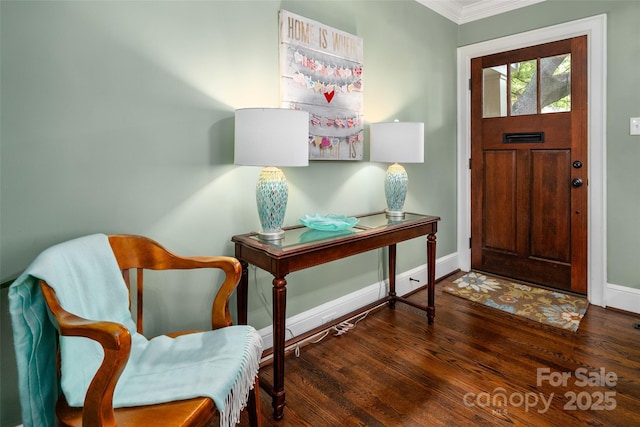 foyer entrance featuring crown molding, baseboards, and wood finished floors