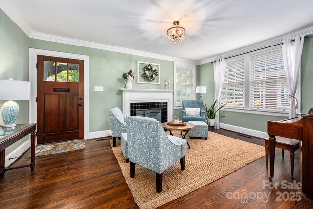 living room featuring wood finished floors, crown molding, a fireplace, and plenty of natural light