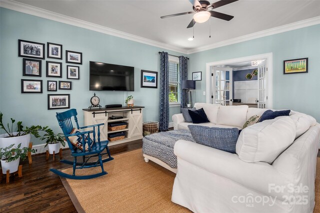 living area featuring wood finished floors, ceiling fan, ornamental molding, and baseboards